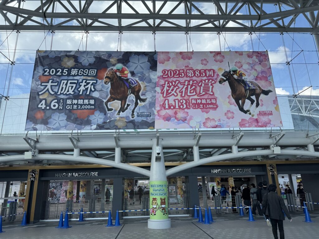 大阪杯と桜花賞の大きな看板が掲げられた阪神競馬場の入場門